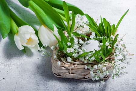 Easter symbols with tulips and eggs on the tableの写真素材