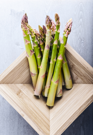 Bunch of green fresh asparagus in a wooden boxの写真素材