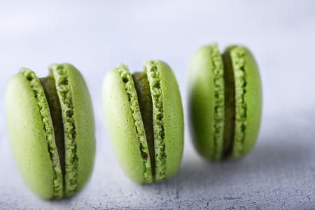 Three green french pistachios Macaroons on a tableの写真素材