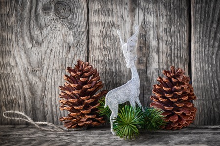 Home decor pine cones  and white deer on a wooden background.の写真素材