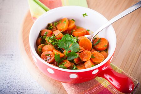 Baby carrots cooked with garlic, honey and parsley.の写真素材