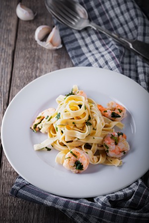 Tagliatelle with shrimps placed on a wooden surfaceの写真素材