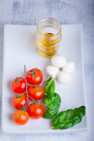 Caprese salad ingredients on a white plateの写真素材