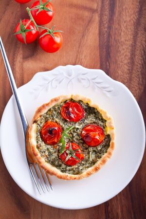 Mini Spinach Quiche with tomato served on a plate.の写真素材