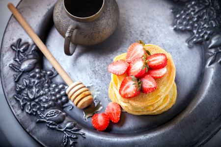 Stack of sweet pancakes with strawberry and honey.の写真素材