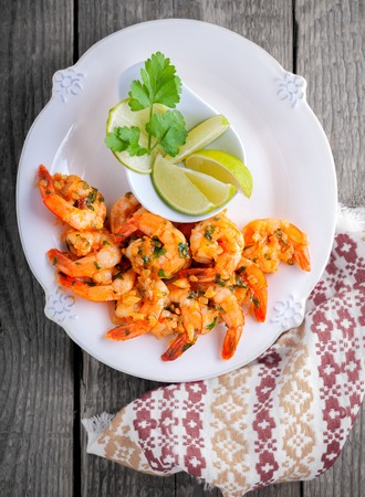Fried Prawns with lemon served on a wooden surface.の写真素材