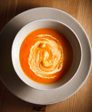 Pumpkin soup with cream served on a tableの写真素材