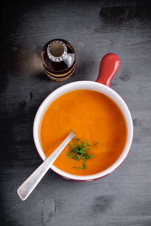 Pumpkin creme soup with a spoon served on a table.の写真素材