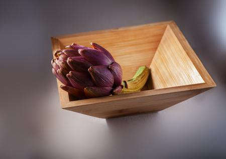 Fresh Artichoke in a square wooden plate.の写真素材