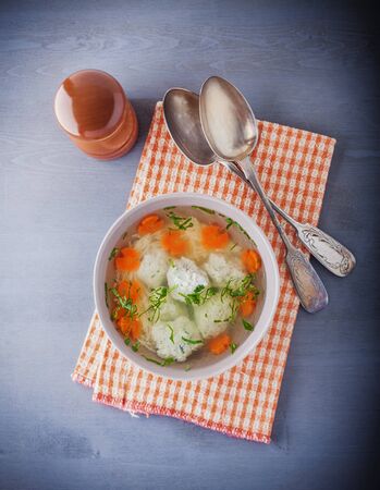 Chicken soup with meatballs and vegetables with a napkin.の写真素材