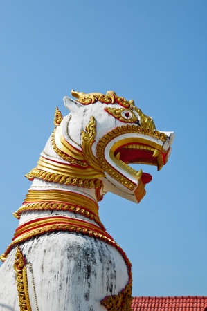 antique guardian lion sculpture in front of the temple, thailand