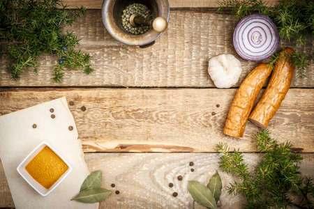 Cooking on a wooden table with ingredients and sausageの写真素材