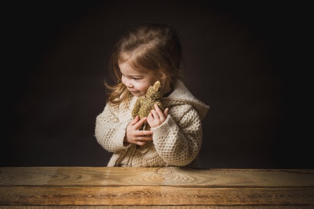 poor little girl hugs a teddy bear strawの写真素材