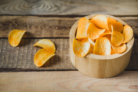 chips in a wooden bowl on the tableの写真素材