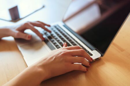 view of the hands of a woman working on the computer in the morningの写真素材