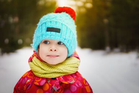 little girl on a walk in the winter, snow-covered forestの写真素材