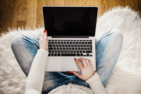 top view of a young woman with a computer on her lapの写真素材