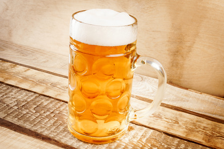 delicious golden beer on old wooden tableの写真素材
