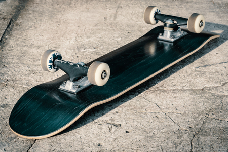 Black skateboard isolated on a concrete background in skateparkの写真素材