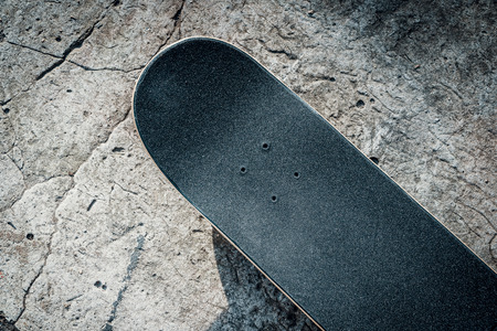 Black skateboard isolated on a concrete background in skateparkの写真素材