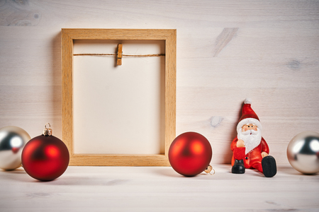 Christmas card with decorations on a wooden table with blank frameの写真素材