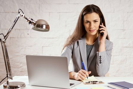 beautiful young businesswoman working in the office with a computer and documentsの写真素材