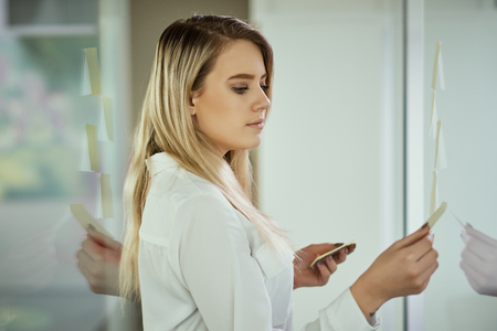 beautiful young businesswoman poses in a sunny skyscraper officeの写真素材