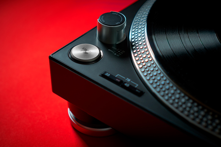 closeup on a modern black turntable on an intense red backgroundの写真素材