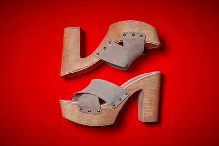 Top view of female beige shoes on an intense red backgroundの写真素材
