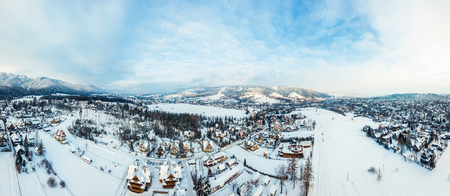 aerial view of a small snowy town and mountains in winterの写真素材