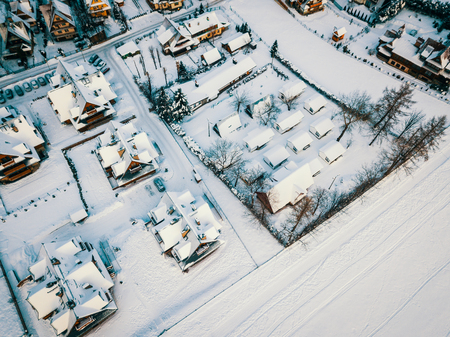 aerial view of the snow-covered roofs of a small village in winter in the mountainsの写真素材
