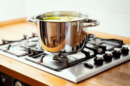 pot with boiling delicious and fragrant broth on the gas stove in the kitchenの写真素材