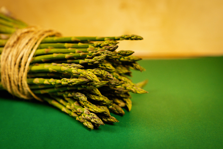 fresh asparagus tied with a thin string on a green summer backgroundの写真素材