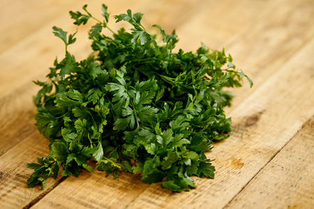 bunch of fresh green parsley on an old wooden kitchen tableの写真素材