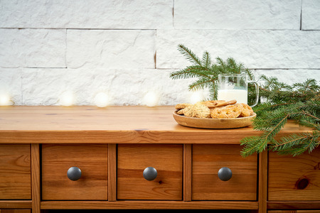 Christmas plate with delicious cookies on an old shelf on the background of a white brick wallの写真素材