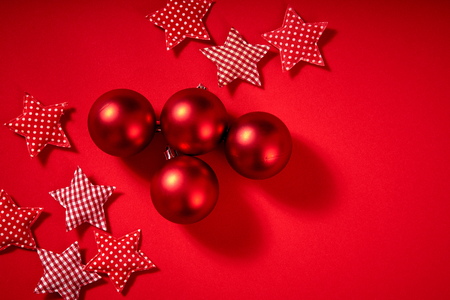 beautiful Christmas red baubles and stars on a red backgroundの写真素材