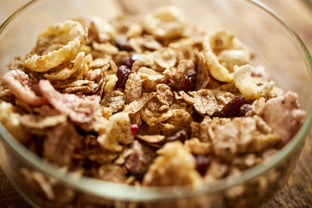 Closeup on a healthy morning breakfast bowl full of organic granola on an wooden tableの写真素材