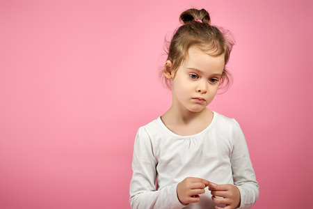 portrait of a cute little girl in tulle skirt on a pink backgroundの写真素材