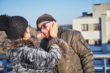happy joyful seniors couple warmly dressed standing on the balcony.の写真素材