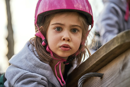 Adorable little girl in helmet at the playgroundの写真素材