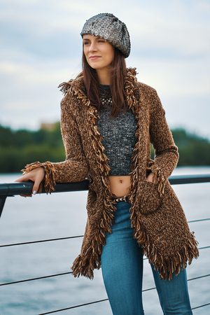 Beautiful young woman posing on the promenade at the river in the cityの写真素材