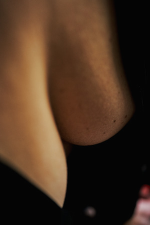 Closeup of  beautiful woman's bust in satin black bathrobe.の写真素材