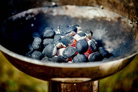 Closeup of glowing coal in metal grill on summer day in the gardenの写真素材