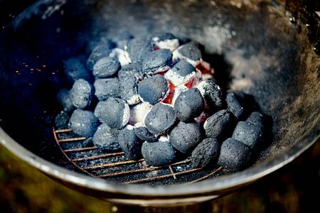 Closeup of glowing coal in metal grill on summer day in the gardenの写真素材