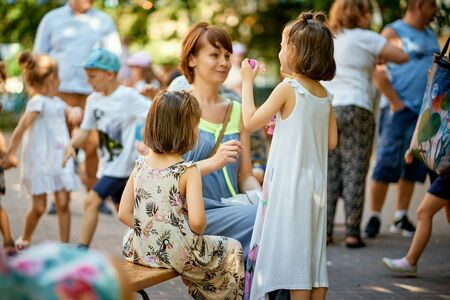 Portrait of mother and littles daughters at family picnic in the park.