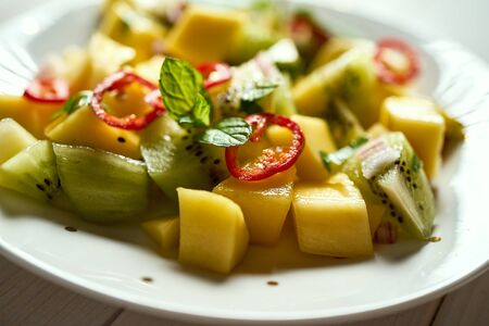 Fresh organic colorful salad with melon on white wooden tableの写真素材