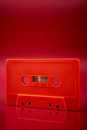 old orange audio cassette on the dark red backgroundの写真素材