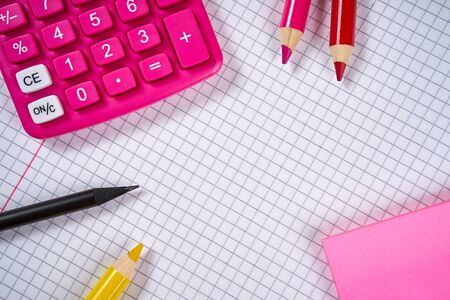open blank notebook with checkered pages and calculator and pencilの写真素材