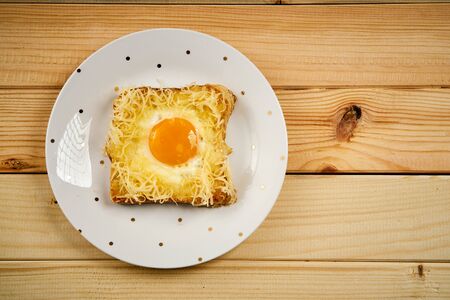 Delicious toast with fried egg on wooden kitchen tableの写真素材