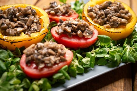 Peppers stuffed with champignons with lettuce on wooden tableの写真素材